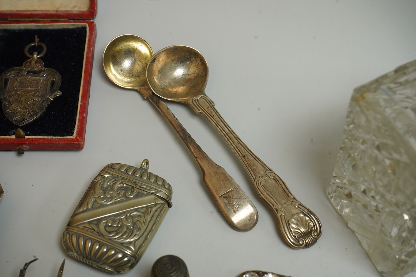A small collection of silver and white metal charms, including Holy Bible, Penny Farthing, hedgehog and squirrel, together with a silver compact and ashtray, a silver and paste brooch, nut vesta, pipe, etc.